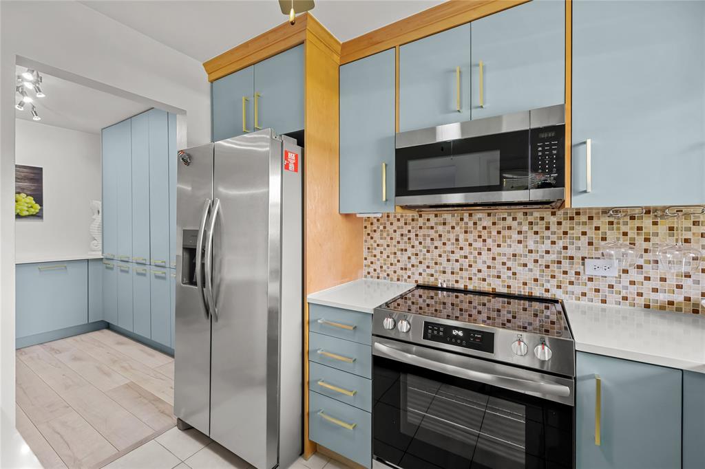 808 Southeast 7th Street, Unit 105B Deerfield Beach, FL 33441 - Photo 16 of 43 a kitchen with granite countertop a stainless steel stove and refrigerator