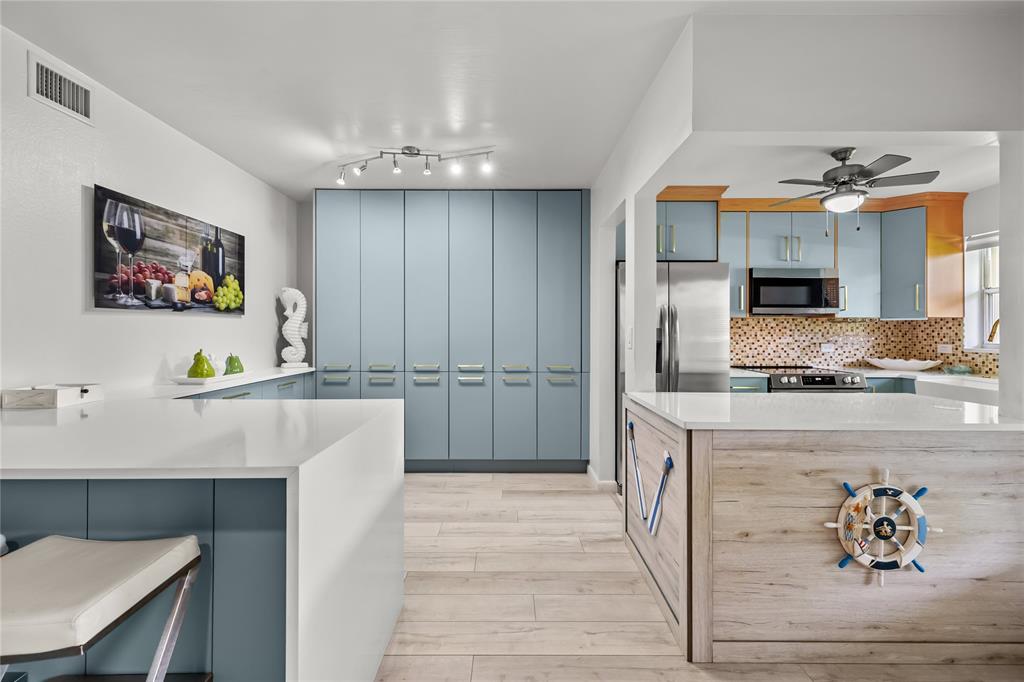 808 Southeast 7th Street, Unit 105B Deerfield Beach, FL 33441 - Photo 18 of 43 a kitchen with stainless steel appliances kitchen island granite countertop a refrigerator and a stove top oven