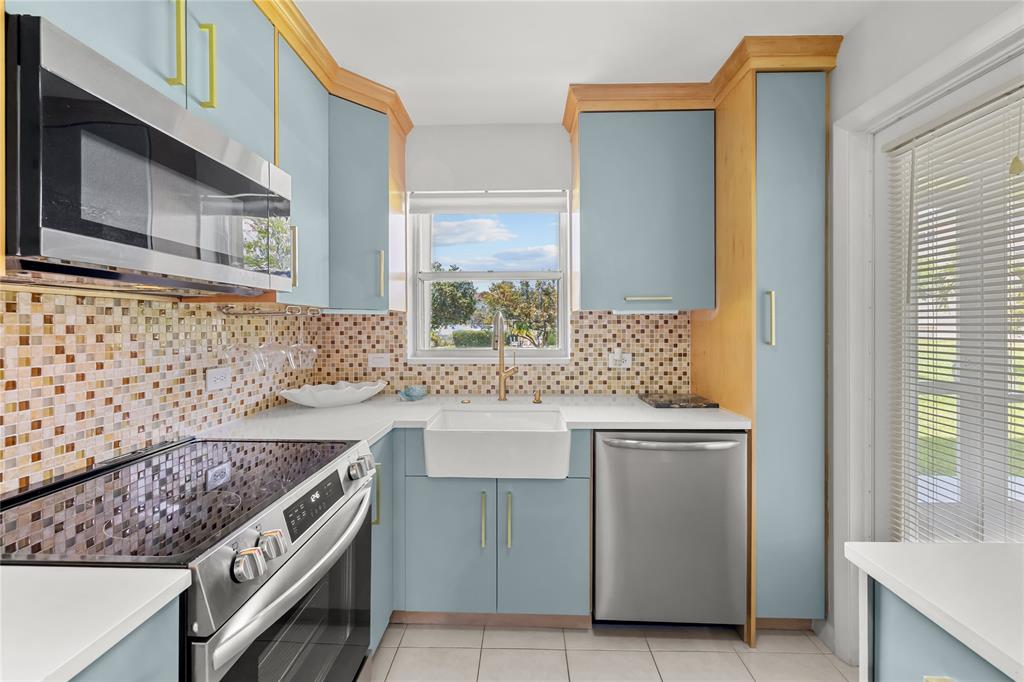 808 Southeast 7th Street, Unit 105B Deerfield Beach, FL 33441 - Photo 19 of 43 a kitchen with a sink stove and cabinets