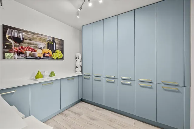 a hallway with a computer on a table and a flat screen tv