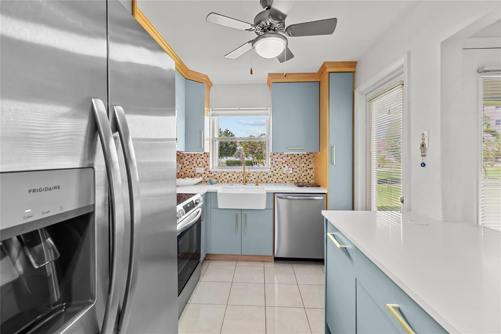 808 Southeast 7th Street, Unit 105B Deerfield Beach, FL 33441 - Photo 23 of 43 a kitchen with stainless steel appliances granite countertop a sink a stove and a refrigerator