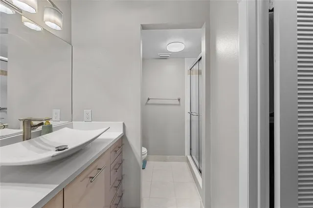 a bathroom with a granite countertop sink a toilet and a mirror