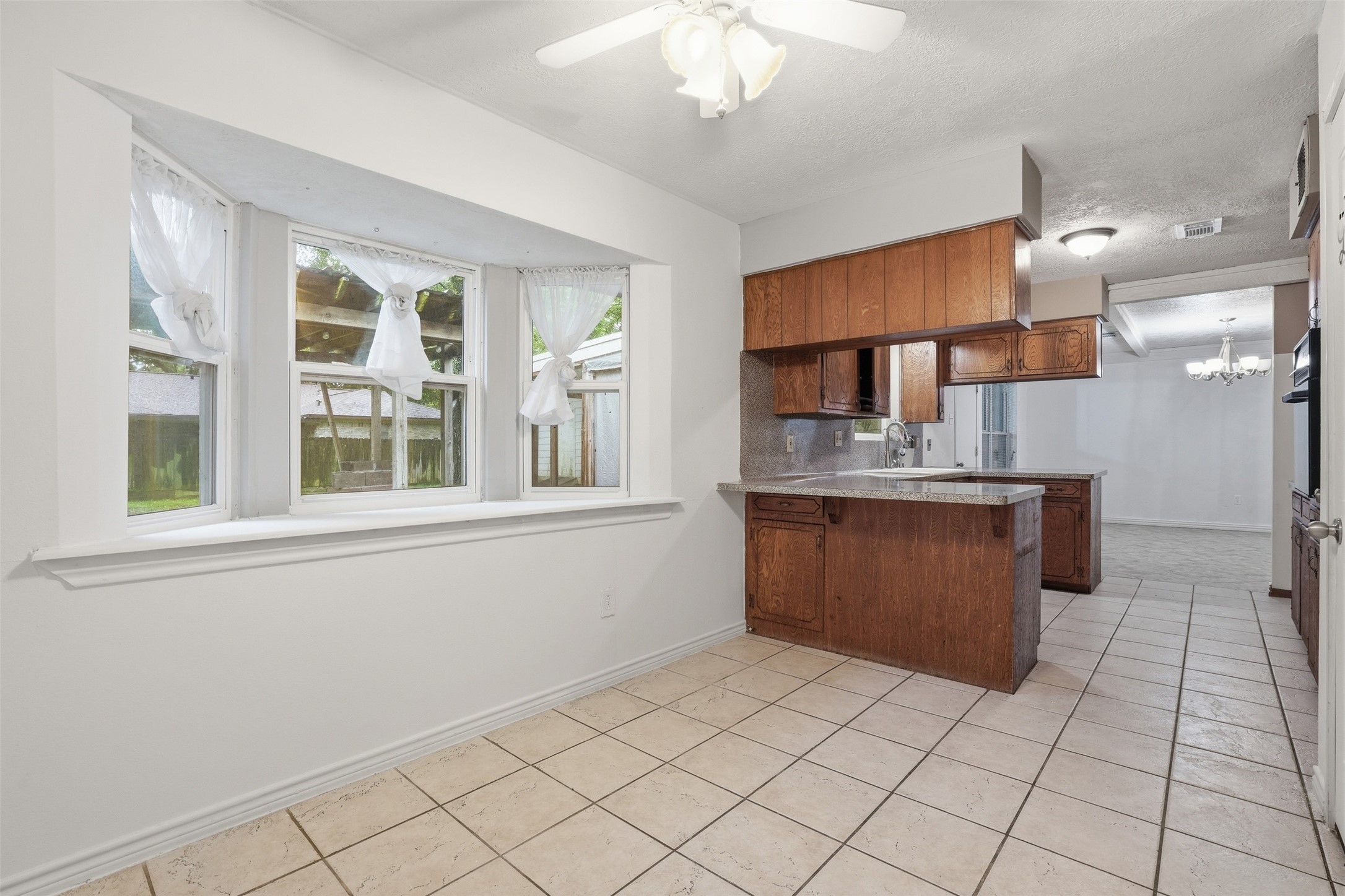 2605 Burke Road Pasadena, TX 77502 - Photo 5 of 29 a kitchen with stainless steel appliances kitchen island granite countertop a sink counter space cabinets and a window