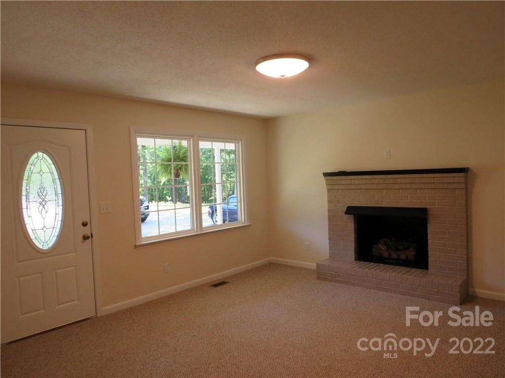 156 Eskimo Drive Bostic, NC 28018 - Photo 7 of 25 a view of an empty room with a fireplace and a window