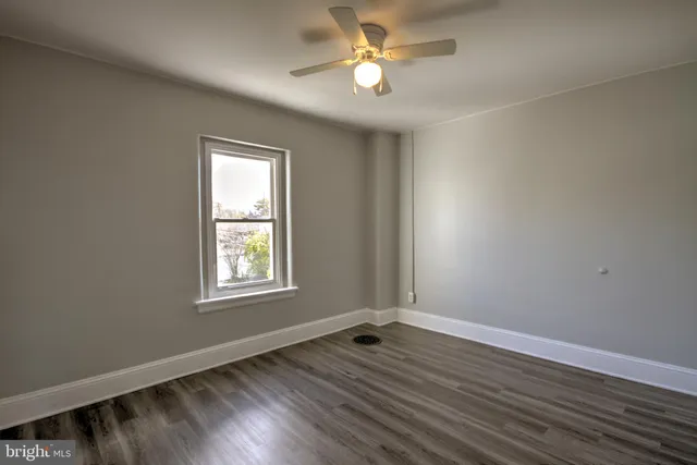 wooden floor in an empty room with a window