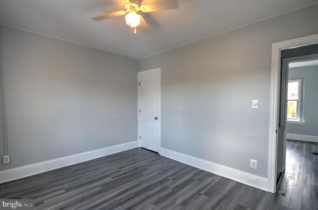 a view of an empty room with wooden floor