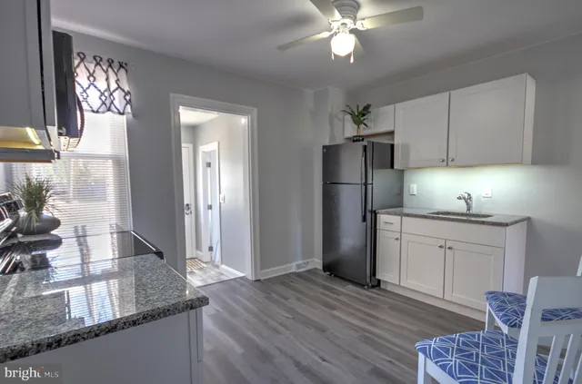 a kitchen with granite countertop kitchen island stainless steel appliances a sink stove and refrigerator