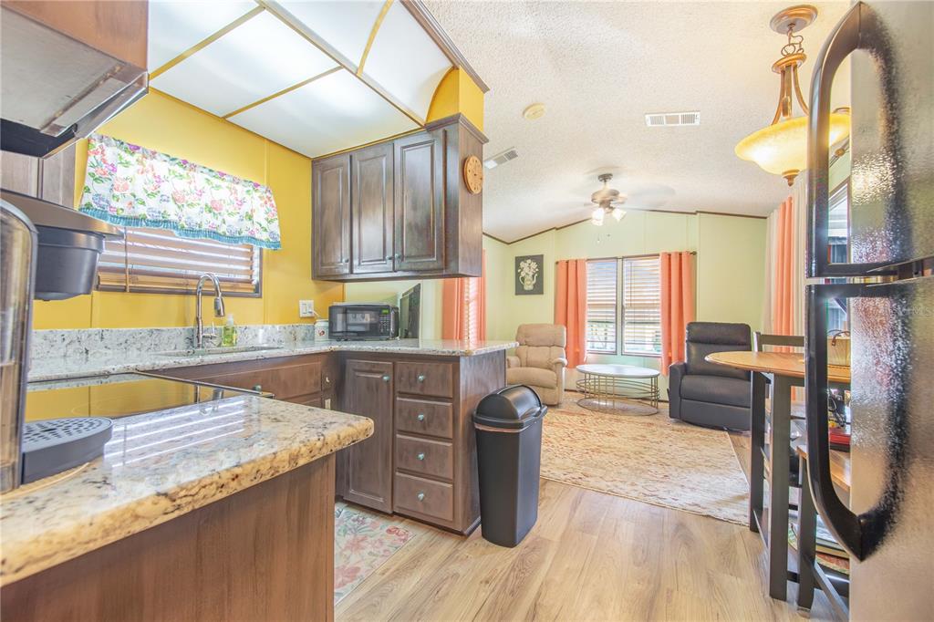 475 Pine Loop Frostproof, FL 33843 - Photo 11 of 40 a kitchen with a stove a sink and a wooden cabinets