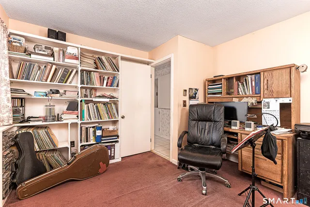 a view of a workspace with furniture and a bookshelf