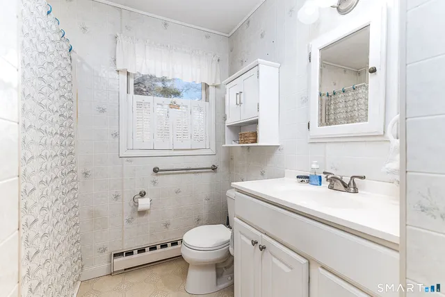 a bathroom with a sink toilet vanity and window