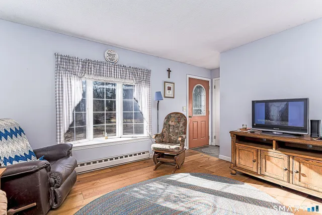 a living room with furniture a window and a flat screen tv