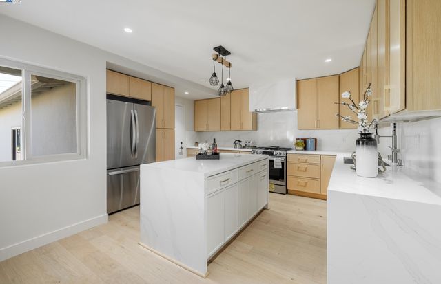 a large kitchen with kitchen island a sink stainless steel appliances and cabinets