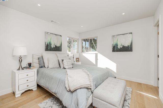 a bedroom with a bed and a painting on the wall