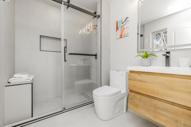 a bathroom with a granite countertop shower a toilet and a sink