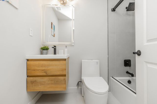 a bathroom with a granite countertop toilet sink and mirror