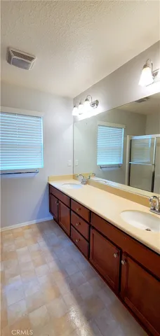 a spacious bathroom with double vanity and a large mirror