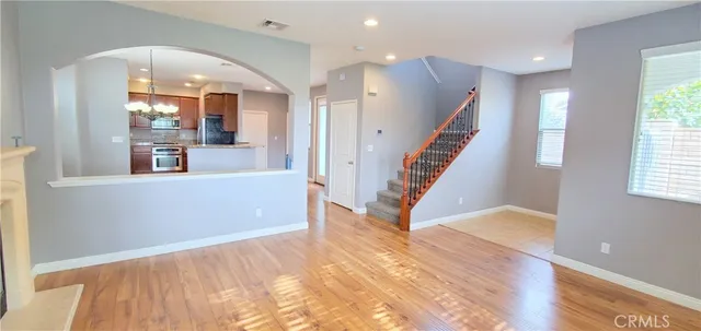 a view of a living room with wooden floor and windows