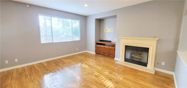 a view of an empty room with a fireplace and a window