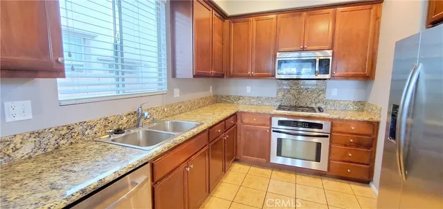 a kitchen with stainless steel appliances granite countertop a sink and a refrigerator