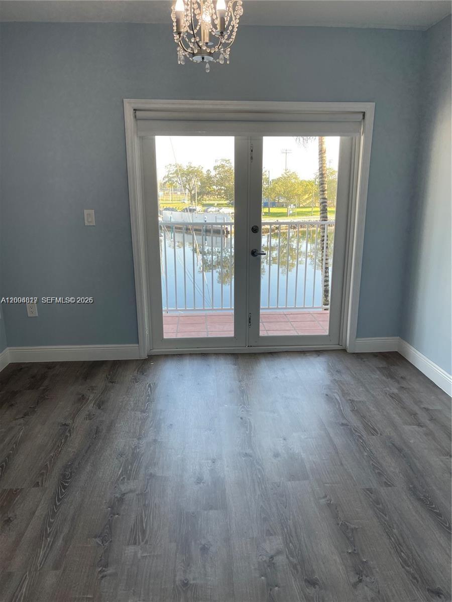 2415 Northwest 16th St Road, Unit 102 Miami, FL 33125 - Photo 5 of 19 an empty room with wooden floor and windows