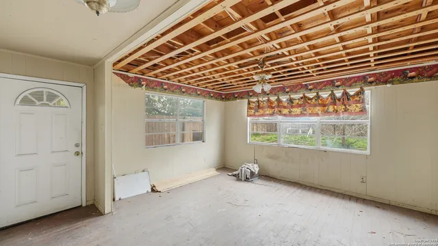 a view of a refrigerator in kitchen and an empty room
