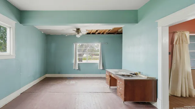 a view of a livingroom with a ceiling fan and windows