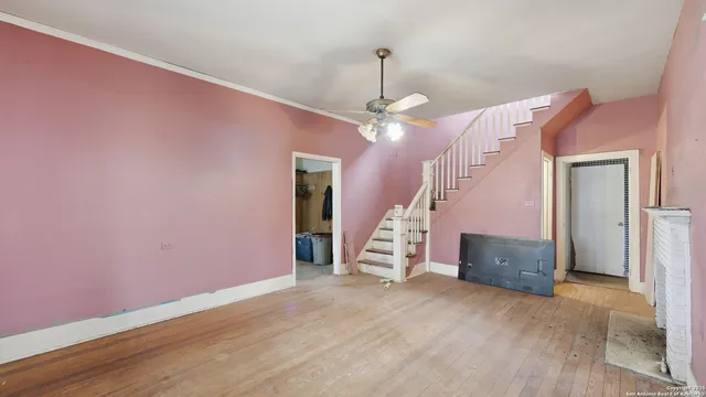 a view of empty room with wooden floor and stairs