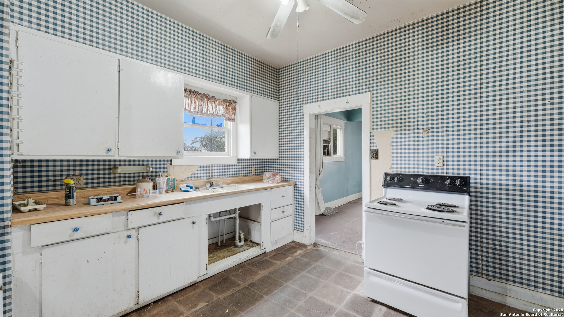536 Commerce Street Pleasanton, TX 78064 - Photo 8 of 31 a kitchen with a sink a stove cabinets and a living room