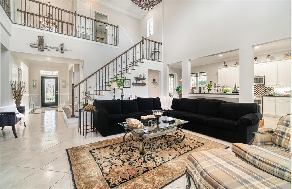 6905 Nobleton Drive Windermere, FL 34786 - Photo 14 of 41 a living room with furniture a fireplace and kitchen view