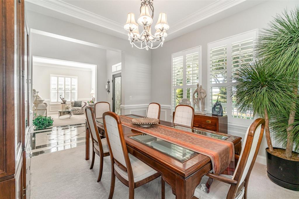 6905 Nobleton Drive Windermere, FL 34786 - Photo 16 of 41 a dining room with furniture a large window and a chandelier