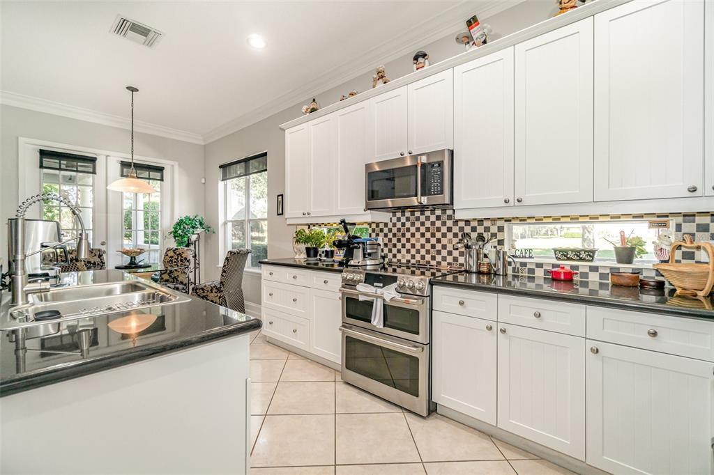 6905 Nobleton Drive Windermere, FL 34786 - Photo 20 of 41 a kitchen with white cabinets and appliances