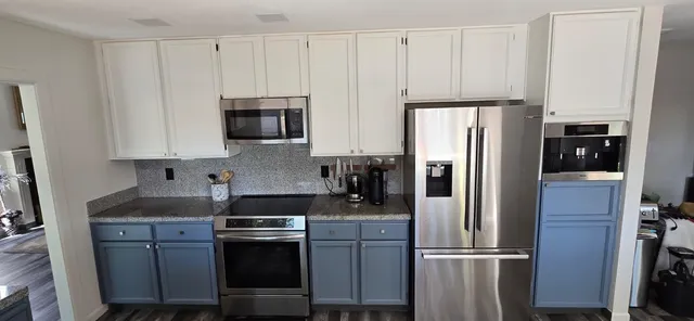 a kitchen with appliances a refrigerator and cabinets