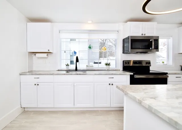 a kitchen with stainless steel appliances white cabinets and a sink