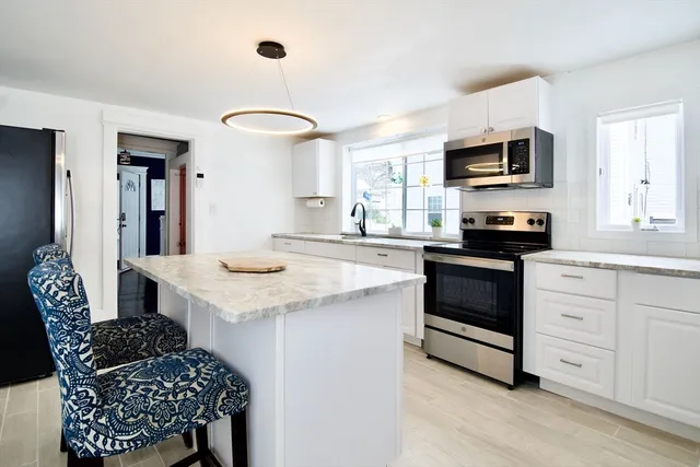 a kitchen with stainless steel appliances kitchen island granite countertop a stove a sink and a microwave