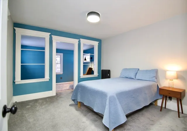 a bedroom with a bed and a large mirror