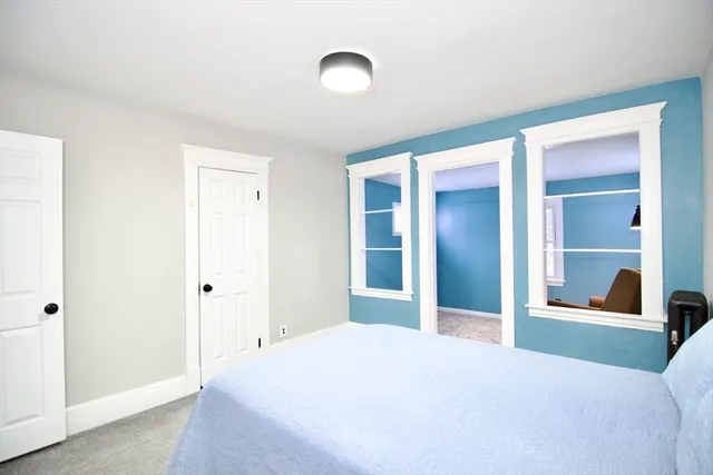 a bedroom with a bed and a large mirror