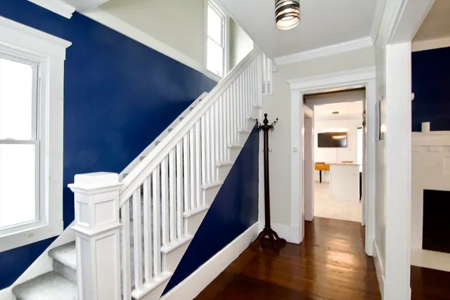 a view of a hallway with wooden floor and staircase