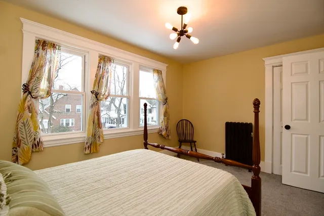 a bedroom with a bed and a large window