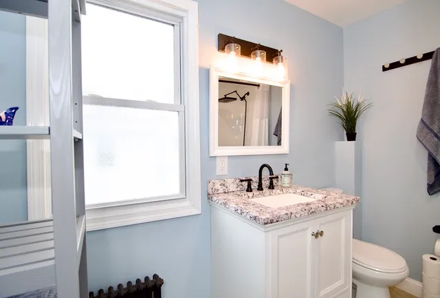 a bathroom with a granite countertop sink and a mirror