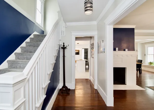 a view of a hallway with wooden floor fireplace and staircase