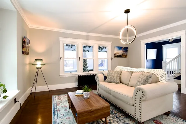 a living room with furniture chandelier and a window