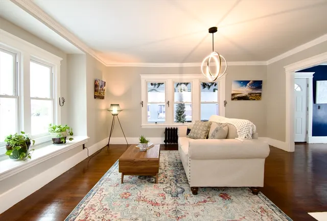 a living room with furniture chandelier and a window