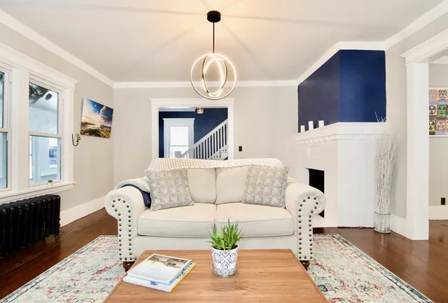 a living room with furniture a wooden floor and a chandelier
