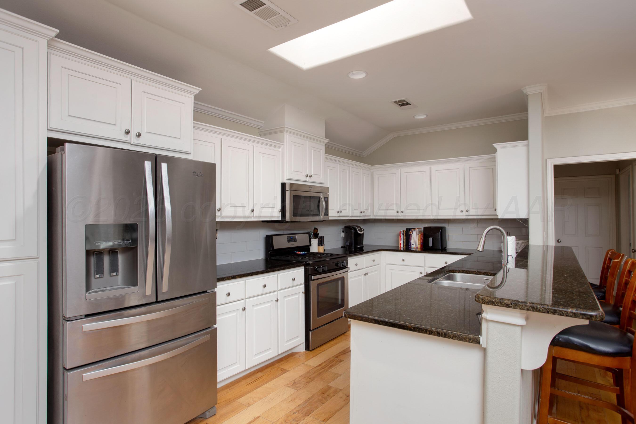 9505 Perry Avenue Amarillo, TX 79119 - Photo 7 of 21 a kitchen with stainless steel appliances and white cabinets