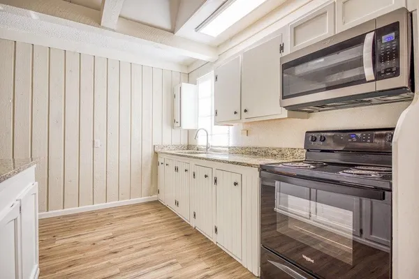 a kitchen with stainless steel appliances granite countertop a stove microwave and cabinets