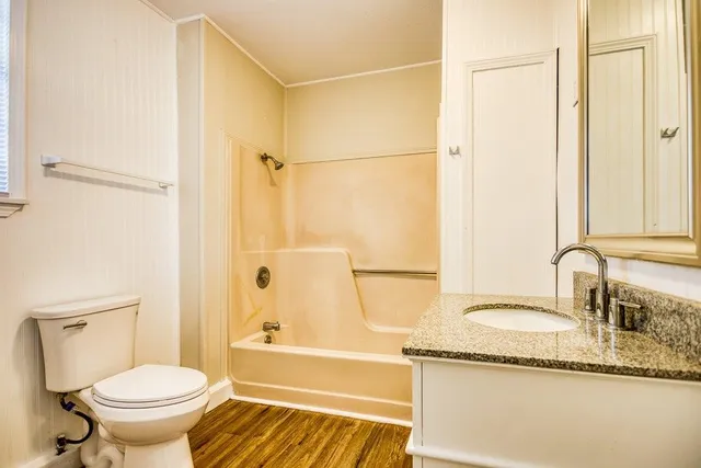 a bathroom with a granite countertop sink toilet and shower