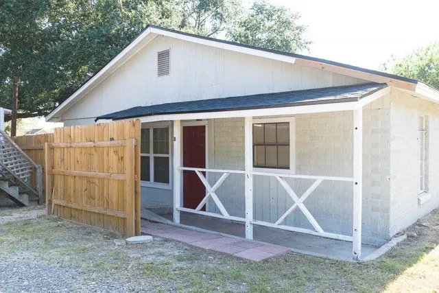 a backyard of a house with table and chairs