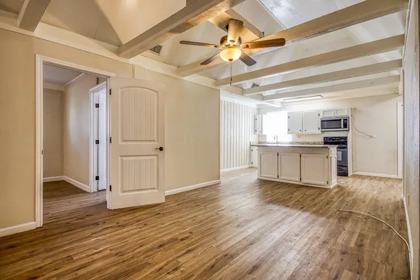 a view of a kitchen with wooden floor a sink and a ceiling fan