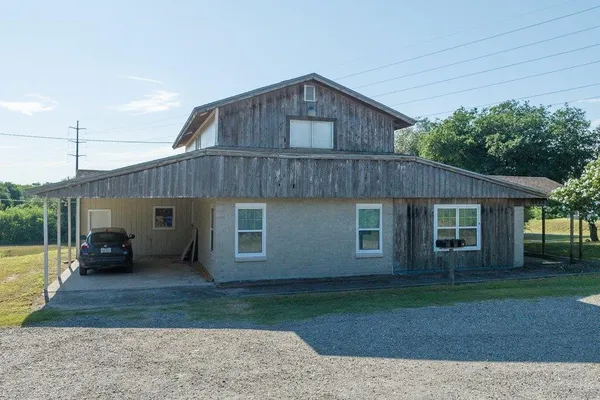 a front view of a house with a yard and trees