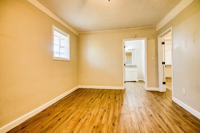 a view of a room with wooden floor and a window